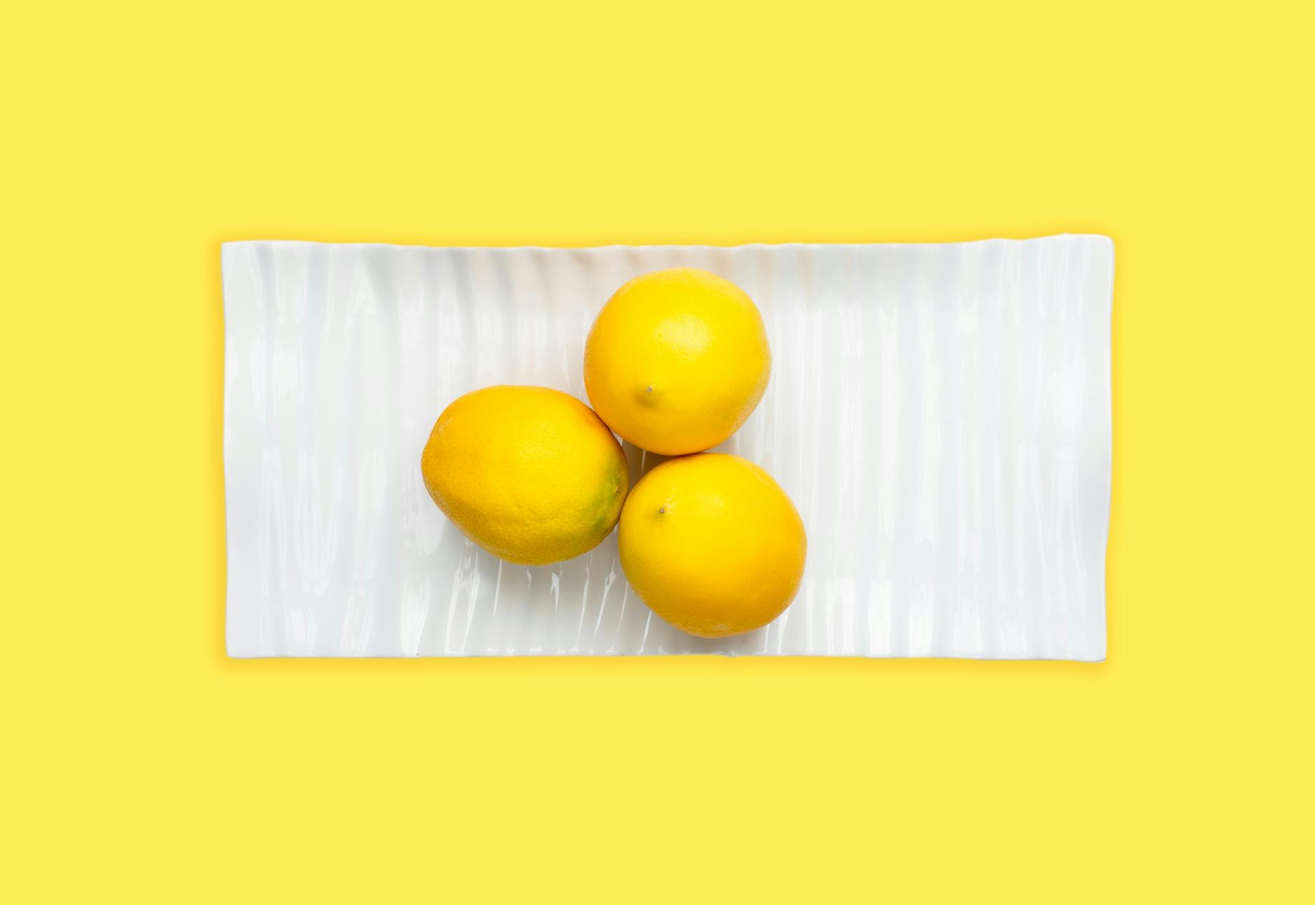 Woman holding blue and pink silicone vibrators in a contemplative manner