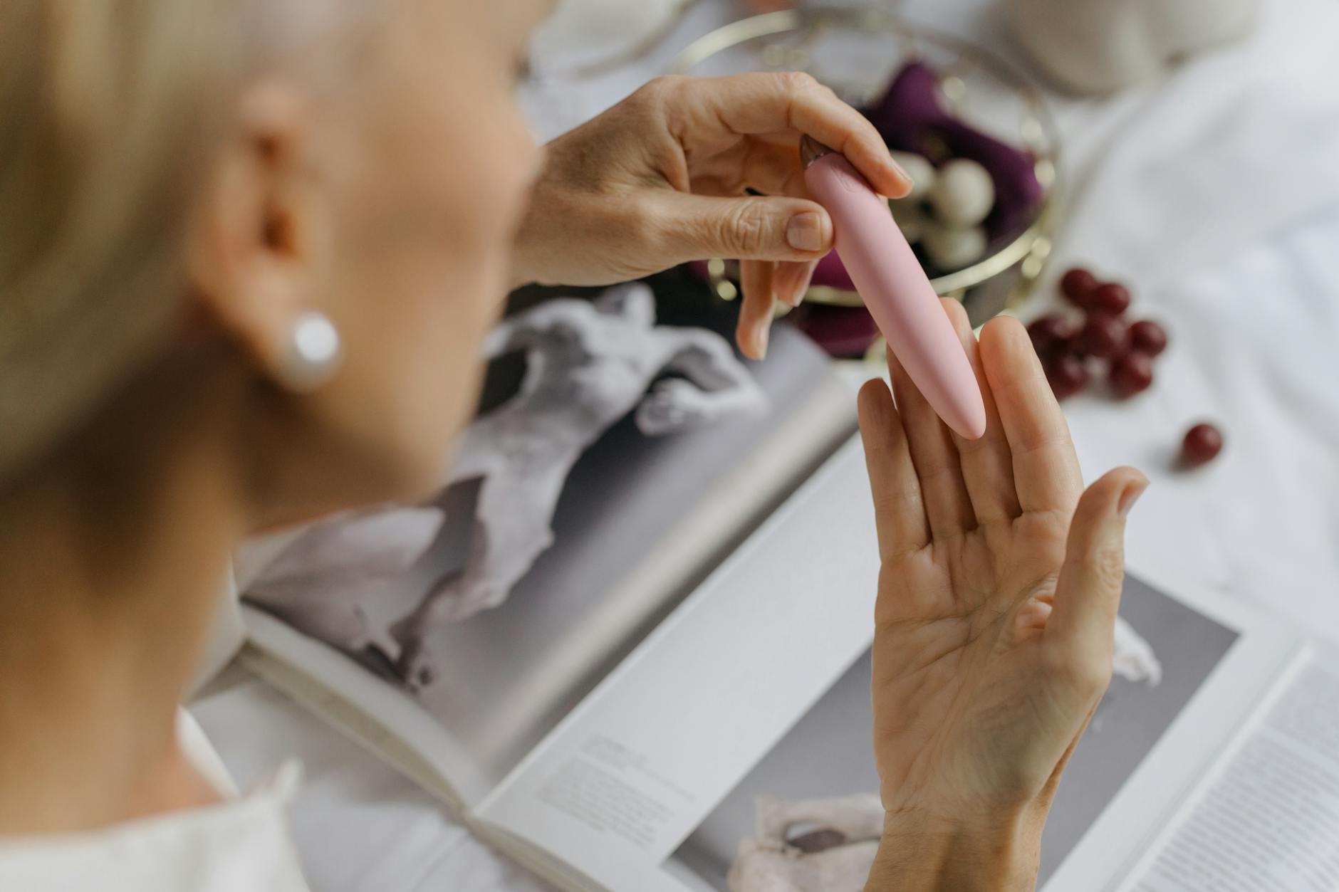 Close-up of a woman holding a pink vibrator, symbolizing intimate self-care and sensual pleasure