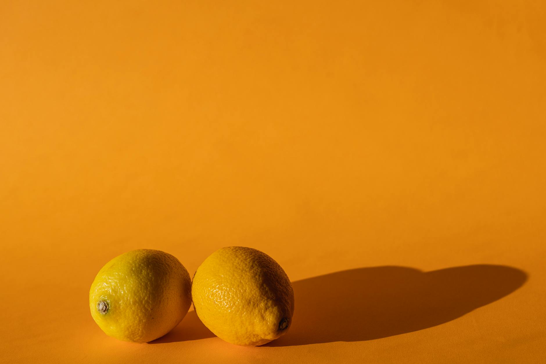 Bright yellow lemons arranged on a yellow studio background symbolizing fresh starts and renewal